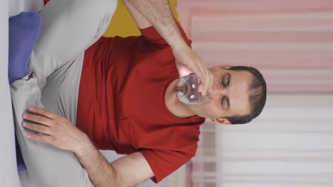 Vertical-video-of-The-sick-man-drinks-a-lot-of-water.